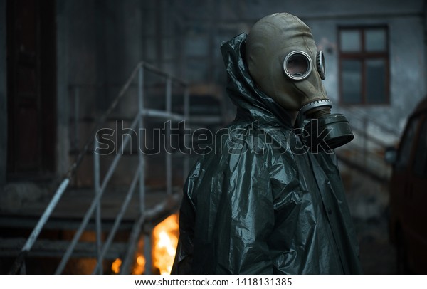 Scientist\
dosimetrist (radiation supervisor) in protective clothing and gas\
mask explores the danger zone. Fire.\
Close-up