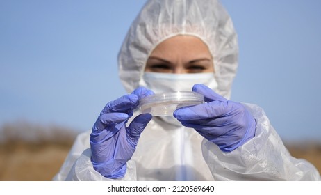 Scientist Or Ecology Expert In Protective Costume With Test Tube Taking Probe For Quality Control. Scientific Research On Environmental Protection.