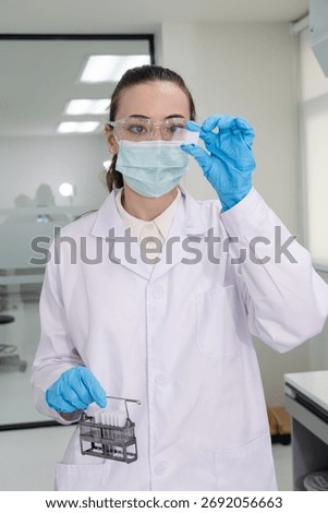 Scientist examining sample with test tubes in laboratory setting for research and analysis