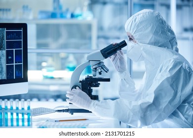 Scientist examining the virus with microscope - Powered by Shutterstock