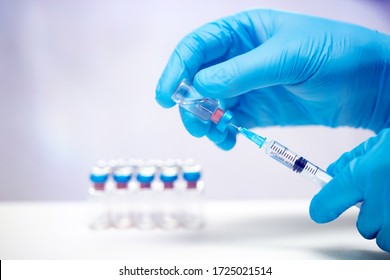 Scientist hand in blue gloves holding coronavirus, covid-19 vaccine disease, preparing for human clinical trials vaccination shot. Medicine and drug concept. - Shutterstock ID 1725021514