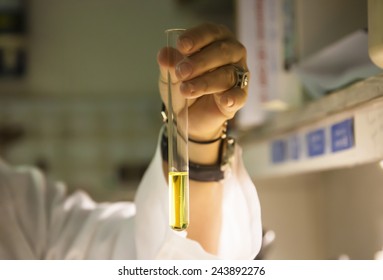 Scientist Hand Holding A Test Tube With A Yellow Aqueous Solution 