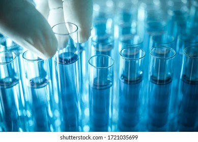 scientist hand pick up test tube from rack