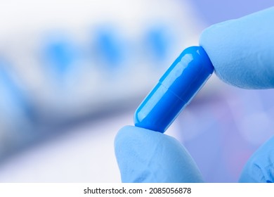 Scientist Hold In Fingers Blue Pill Capsule. New Medical Treatment Or Supplement Laboratory Scientific Research.