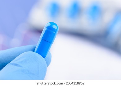 Scientist Hold In Hand Blue Pill Capsule. New Medical Treatment Or Supplement Laboratory Scientific Research.