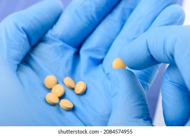 Scientist Hold In Hand Small Pill. New Medical Treatment Or Supplement Laboratory Scientific Research.