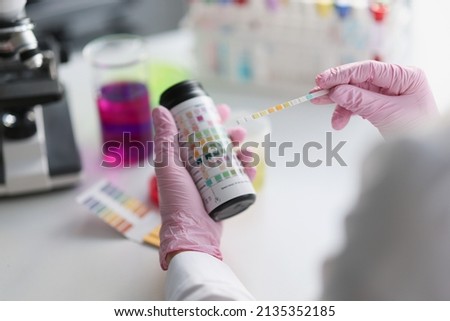 Scientist hold litmus test paper for soil analysis, litmus paper show acidity, chemical analysis