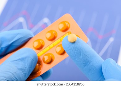 Scientist Hold Small Pill On Fingertip Of One Hand And Blister Pack In Other. New Medical Treatment Or Supplement Laboratory Scientific Research.