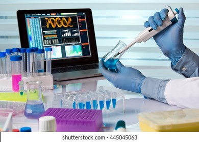 Scientist Holding Flask And Working With Laptop In Lab / Chemical Engineer Working In Laboratory With Pipette And Flask