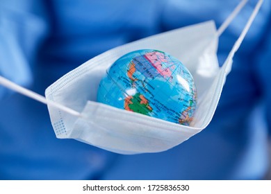 Scientist Holding Globe In Protective Mask