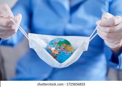 Scientist Holding Globe In Protective Mask