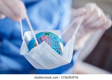 Scientist Holding Globe In Protective Mask