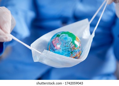 Scientist Holding Globe In Protective Mask