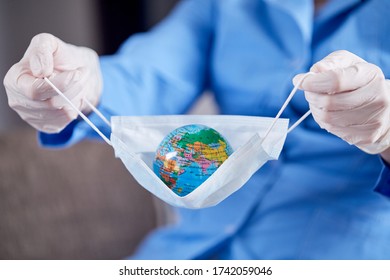 Scientist Holding Globe In Protective Mask