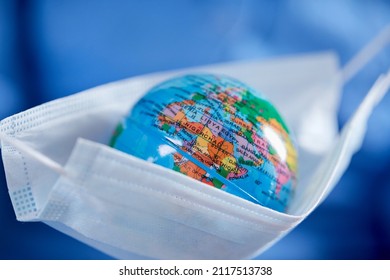 Scientist Holding Globe In Protective Mask