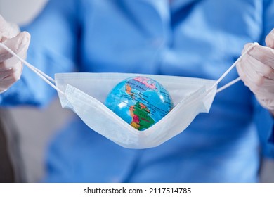 Scientist Holding Globe In Protective Mask