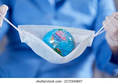 Scientist Holding Globe In Protective Mask