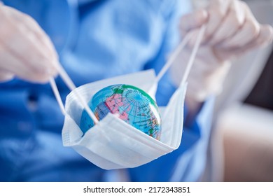 Scientist Holding Globe In Protective Mask