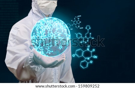 scientist holding sphere of glow chemical formula