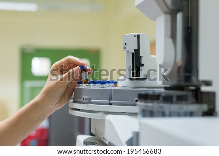 scientist holds an amber vial. Vials in the autosampler of gas chromatography-mass spectrophotometer. Development of a new vaccine against the covid-19 virus. Focus on the center vials Stock photo © 