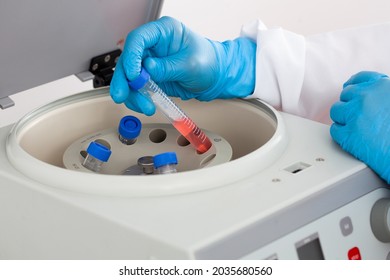 Scientist inserting a tube in a laboratory centrifuge - Powered by Shutterstock