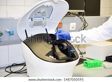 Scientist inserts a sample to a cuvette in spectrometer.  of Organic and Biochemistry.