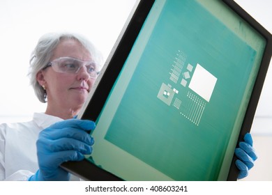 Scientist inspects screen printer mesh for graphene ink in graphene processing factory, close up - Powered by Shutterstock