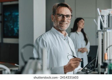 Scientist inventing machinery with female colleague in background at laboratory - Powered by Shutterstock