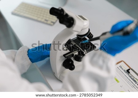 Scientist in laboratory using microscope and micropipette, performing medical research and biotechnology experiment, analyzing samples for scientific discovery and healthcare innovation