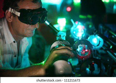 Scientist  in laser vision glasses engaged in research in his lab show movement of microparticles by laser