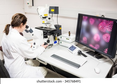 Scientist looking through a microscope at the laboratory