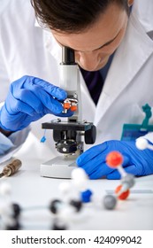 Scientist looking through a microscope in a laboratory