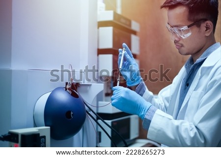 Scientist man analyzing a sample using the high-performance analytical instrument, Mass spectrometer for drug development in medical research.