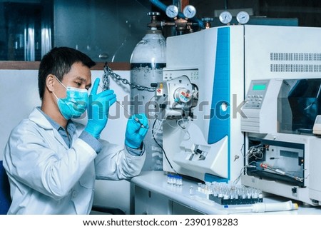 A scientist man injects a sample with a micro syringe into Mass Spectrometer to analyze samples, Mass spectrometry is used to measure mass per charge connected to Liquid Chromatography LC-MS