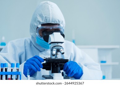 Scientist man look into Microscope research in science laboratory. Asian scientist look at microbiology microscope laboratory equipment chemistry lab. Biochemistry research experiment vaccine concept