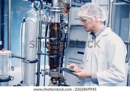 Scientist man working Cannabis CBD oil extraction for medical Science lab. Hemp oil extraction Thin Film Distillation Machine in Laboratory Plants Process.
