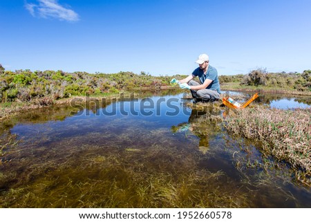 Scientist measuring water quality parameters in a wetland.