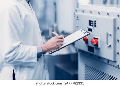 Scientist Medical Factory Staff Working in Science Lab. Medicine factory Technician Employee Check Care Products Quality in Sterilize Room Taking Note in Check list. - Powered by Shutterstock