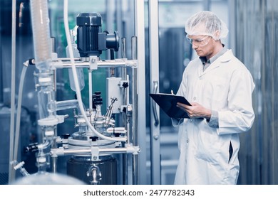 Scientist Medical Factory Staff Working in Science Lab. Medicine factory Technician Employee Check Care Products Quality in Sterilize Room Taking Note in Check list. - Powered by Shutterstock