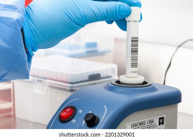 Scientist mixes a biological sample for analysis using a lab vortex mixer with adjustable stirring speed with touch. - Powered by Shutterstock