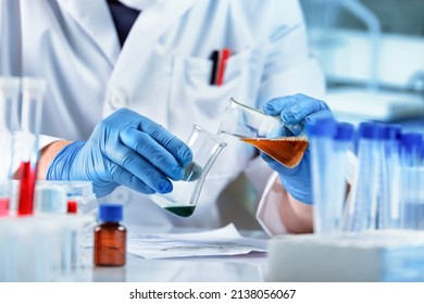 Scientist mixing chemical liquids in the chemistry lab. Researcher working whit fluids in flasks in the chemical laboratory - Powered by Shutterstock