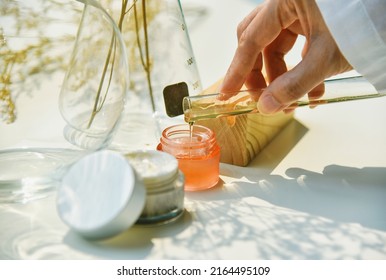 Scientist mixing natural skin care beauty products, Organic botany extraction and scientific laboratory glassware, Blank label cosmetic container for branding mock-up. - Shutterstock ID 2164495109