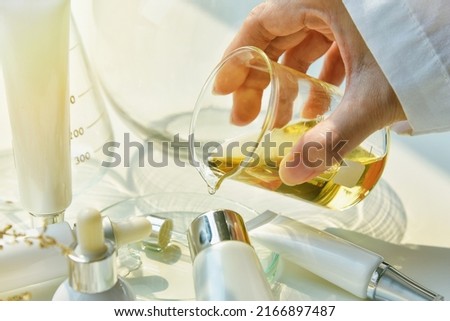 Scientist mixing natural skin care beauty products, Organic botany extraction and scientific laboratory glassware, Blank label cosmetic container for branding mock-up.