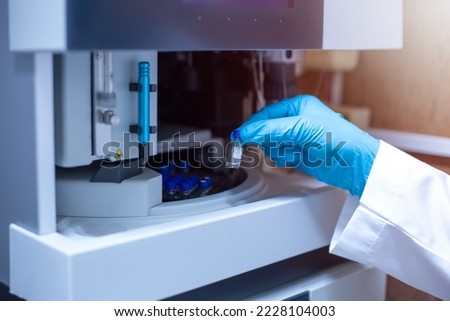 Scientist moved the vial of sample out from the tray autosampler of the Liquid Chromatography Mass Spectrometer LCMS after the analysis was complete.