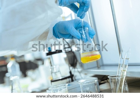 Scientist performs laboratory testing and quality control of oil sample using pipette in a modern research facility