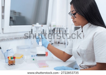 A scientist performs precise lab work while using pipettes and analyzing samples. The setting is a well-equipped pharmaceutical research laboratory.