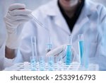 Scientist pipette doppler blue liquid in test tube beaker laboratory science biotechnology biology chemistry medical pharmaceutical DNA medical healthcare research discovery innovation experiment