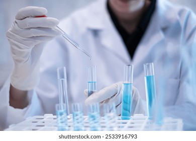 Scientist pipette doppler blue liquid in test tube beaker laboratory science biotechnology biology chemistry medical pharmaceutical DNA medical healthcare research discovery innovation experiment - Powered by Shutterstock