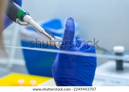 Scientist pipetting sample into vial for DNA testing. scientist loads samples DNA amplification by PCR into plastic PCR strip tubes. Hands in blue gloves holds pipette and test tube. Parental test
