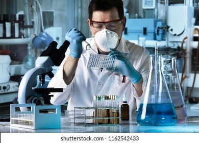 scientist pipetting samples in multi-well plate in the lab / researcher working with microplate in the laboratory    